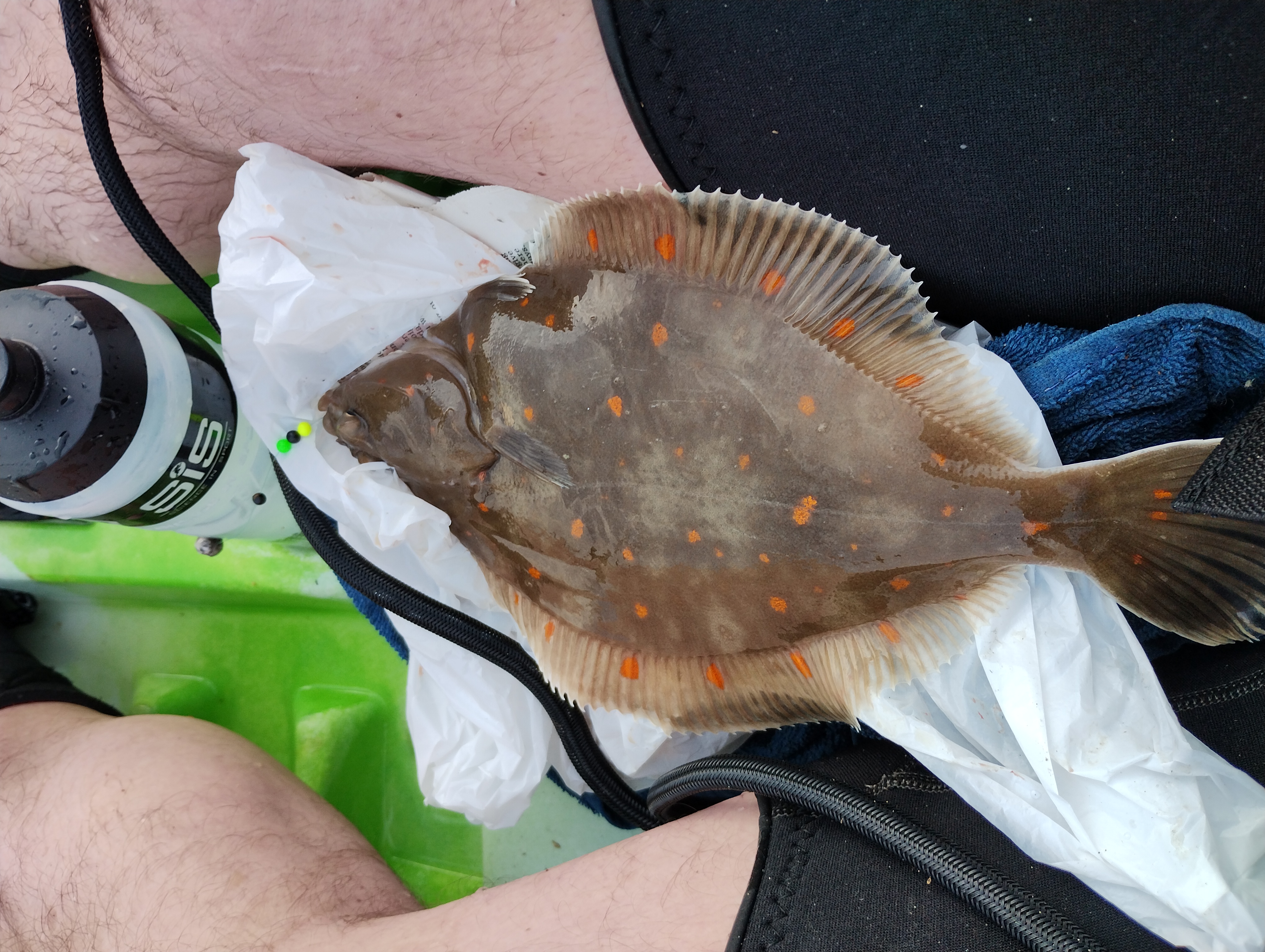 A police laying between an anglers legs on a kayak 