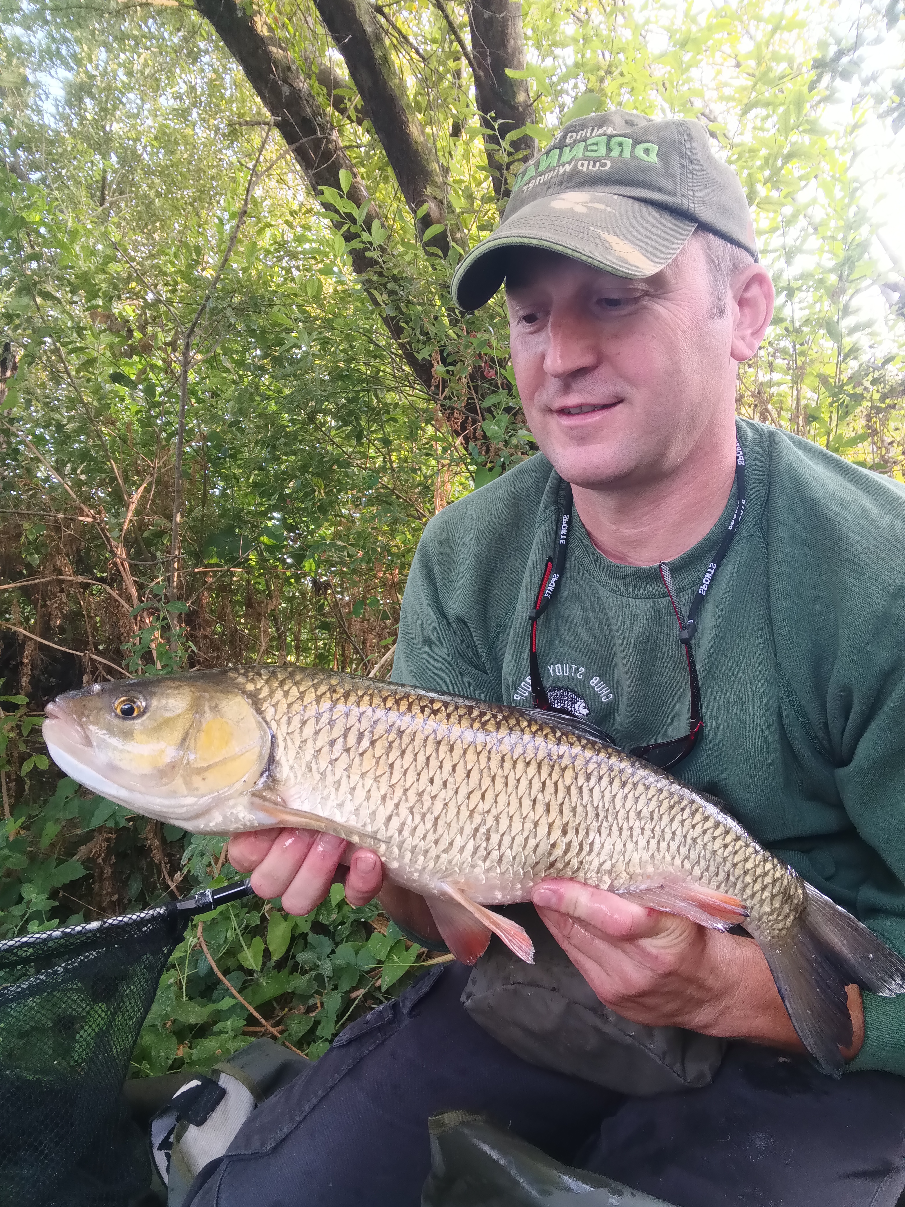 A angler holding a chub up for the camera.